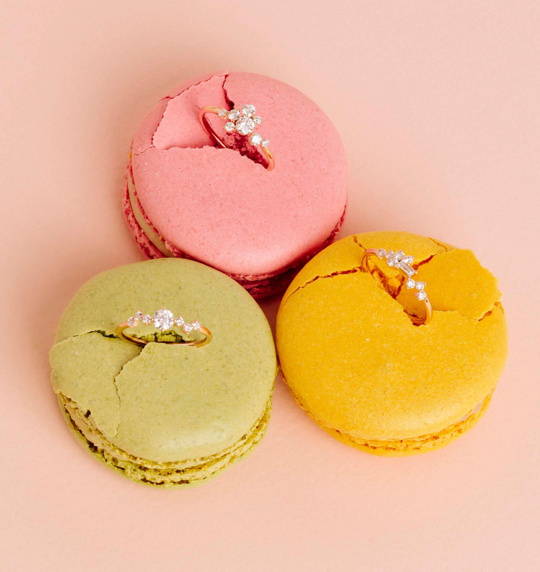 Three diamond rings displayed in pink, green and yellow macarons