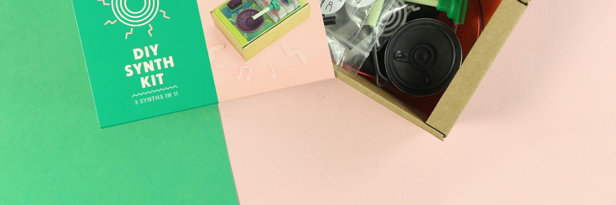 DIY synth kit with electronic components and speaker on a pastel background