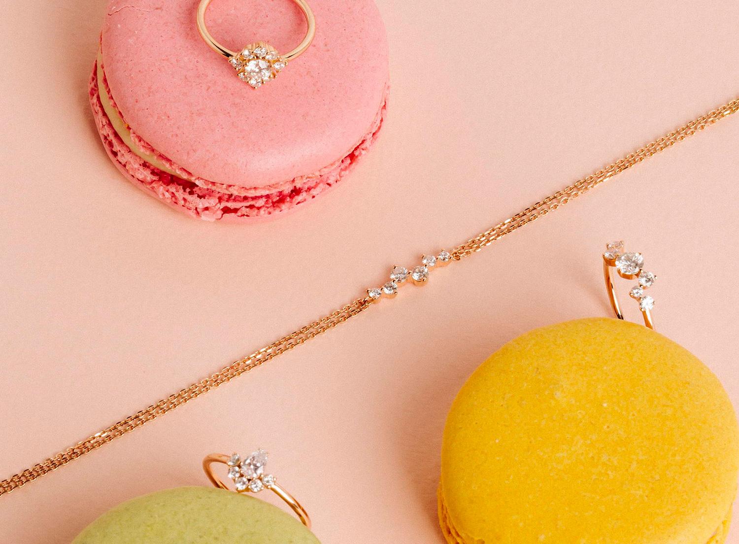 Héloïse & Abélard diamond rings and a bracelet arranged on pink, green and yellow macarons